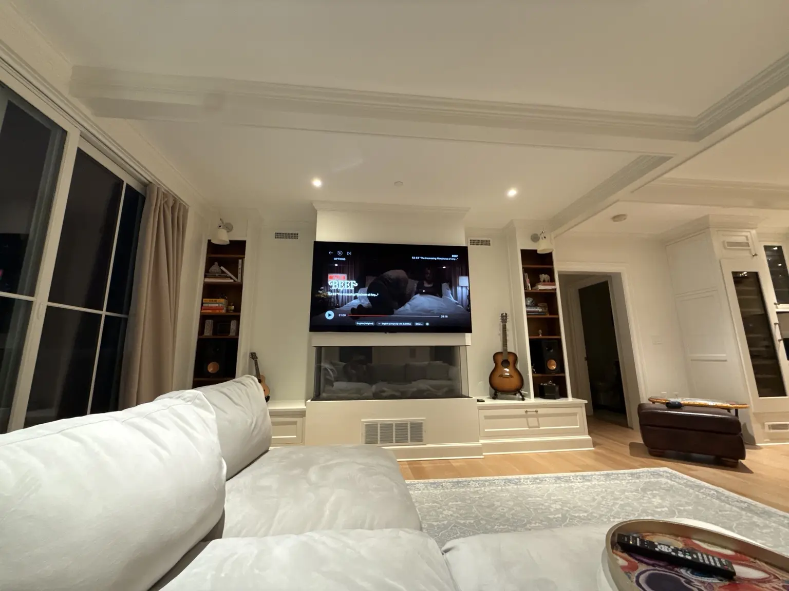 Completed integrated media room with television, speakers and fireplace